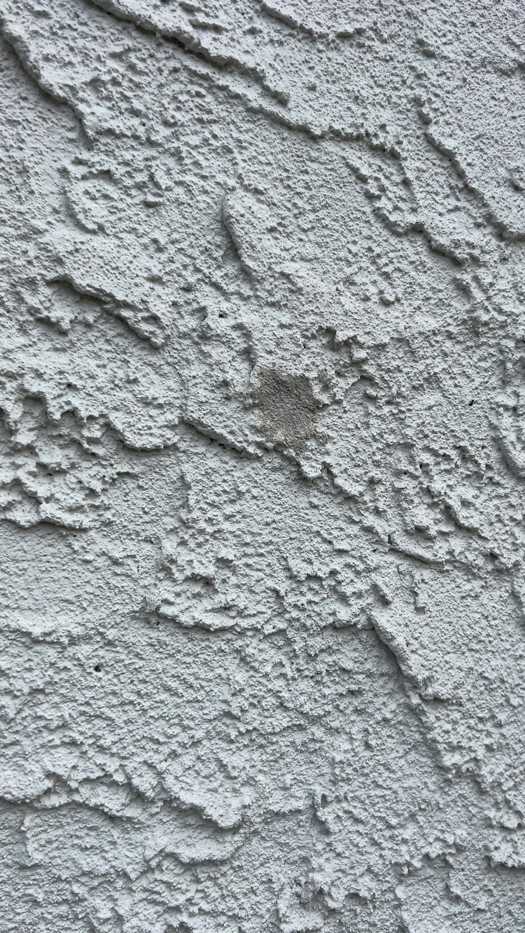 A detail of a patched stucco access point.