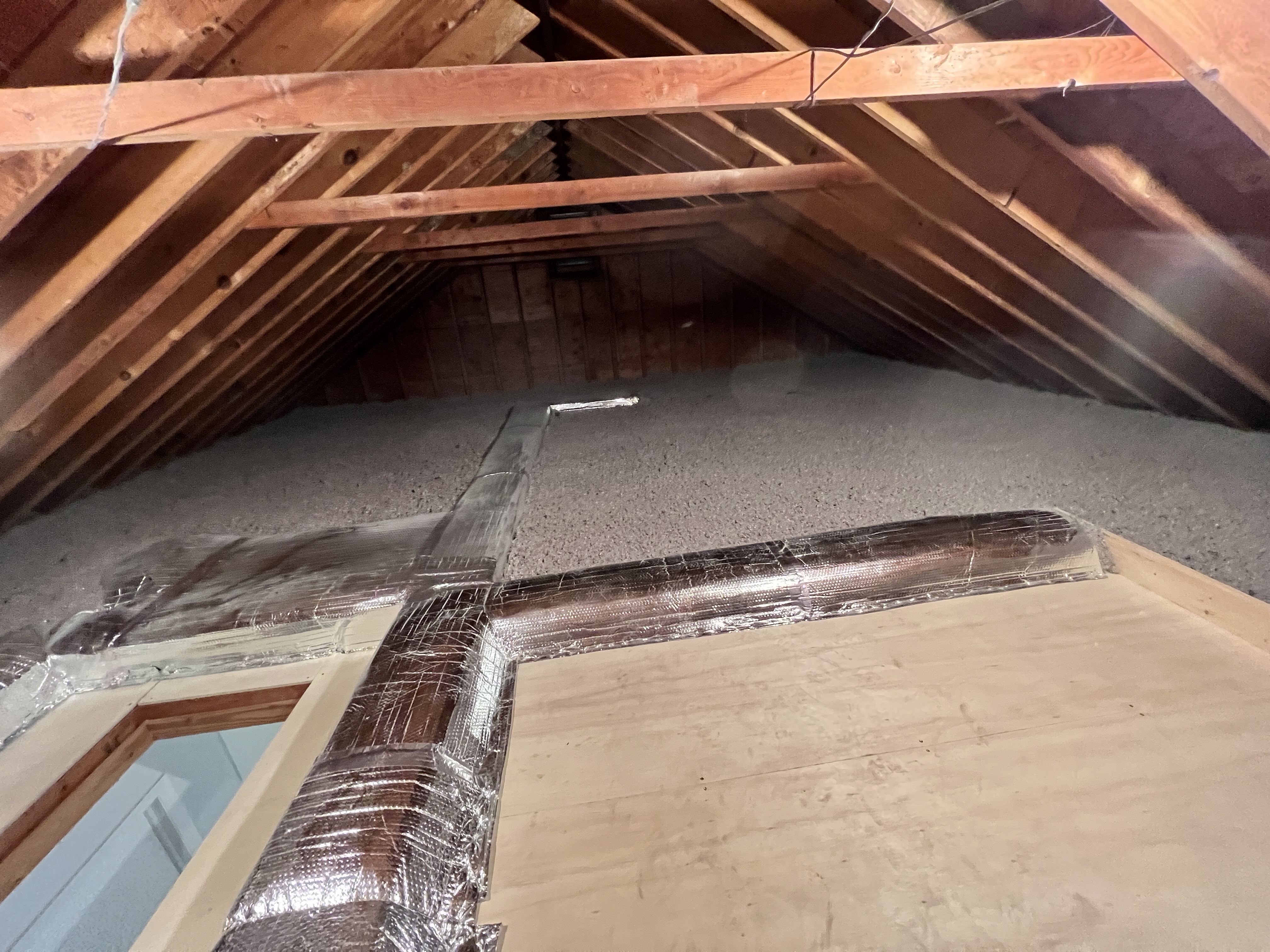 Cellulose coverage around a clearly defined attic access area.
