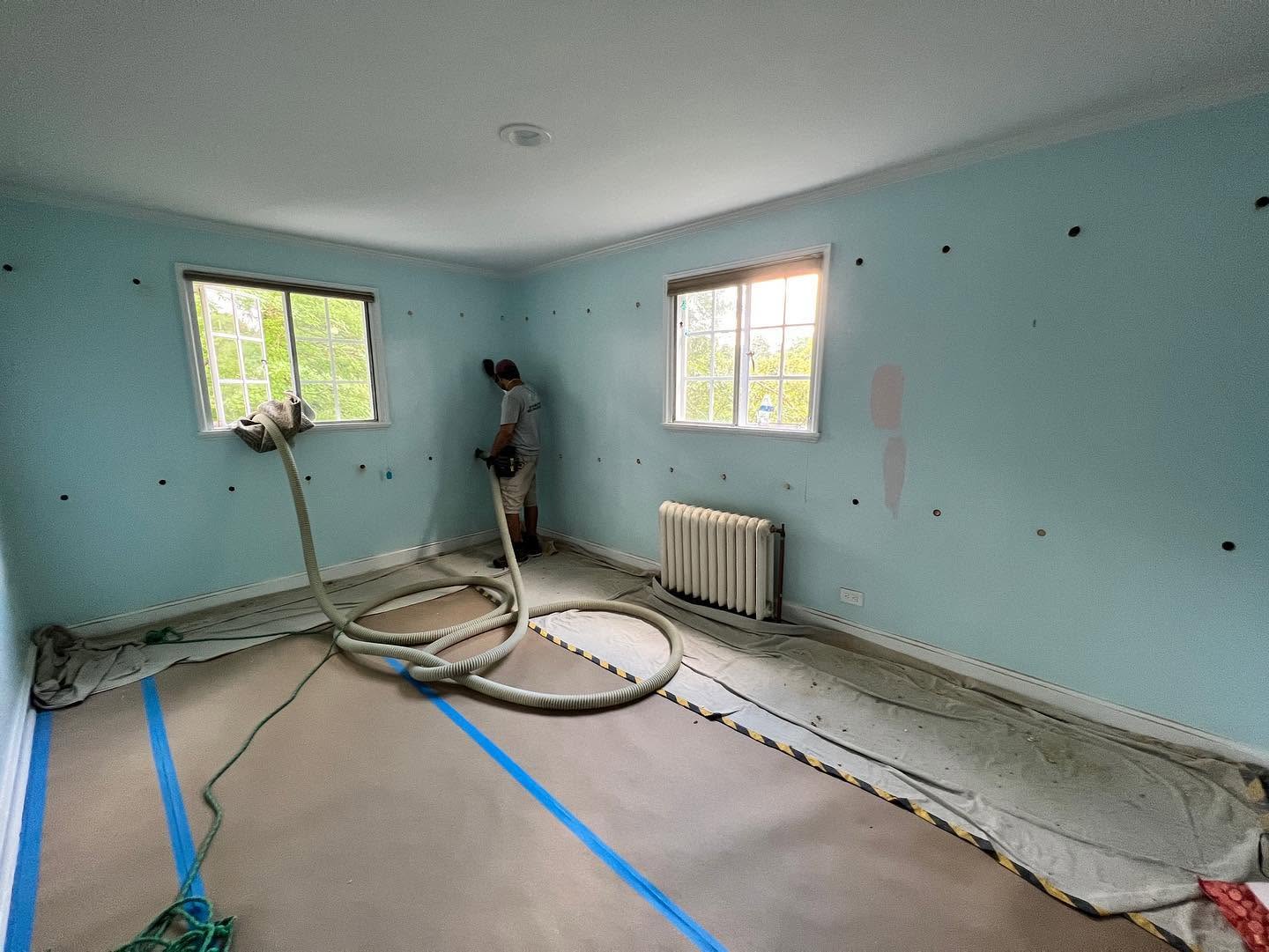 Nu-Way crew member installing cellulose through small wall access holes